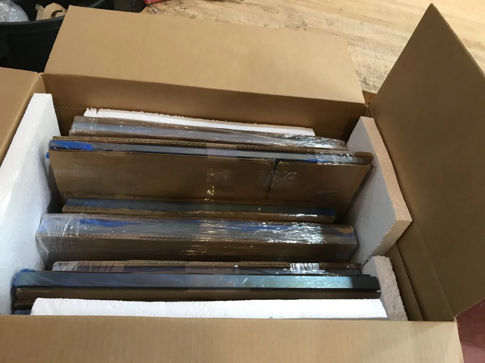 Multiple framed pieces separated and fitted inside a foam-lined carton