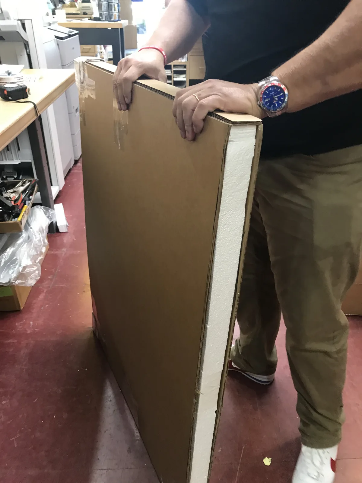 Packing specialist fitting protective panels around framed artwork