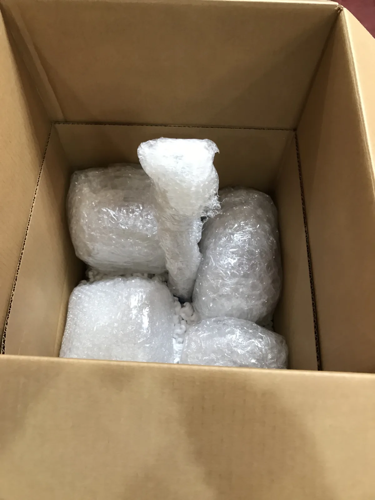 Individually wrapped fragile pieces cushioned inside a carton