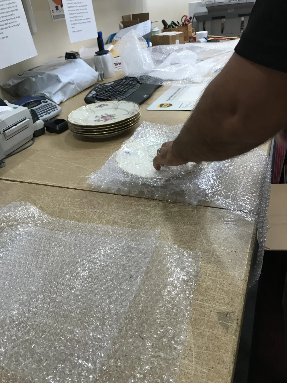 Ceramic pieces being wrapped individually on the packing bench
