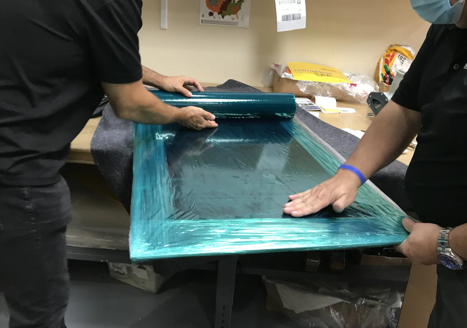 Packing team protecting framed artwork for shipment